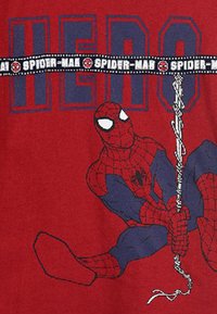 T-shirt rossa con una grafica di Spider-Man. Il design include dettagli blu con la parola "EROE" e un elastico con il marchio Spider-Man.