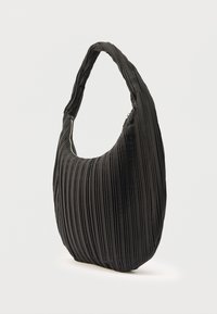 Czarna plisowana torebka na ramię o zakrzywionym kształcie i zamknięciu na zamek błyskawiczny z boku, pokazana na białym tle.