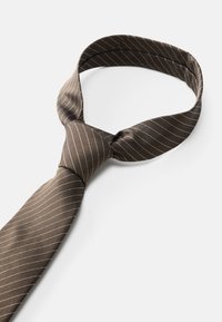 Καφέ ριγέ γραβάτα κατασκευασμένη από ύφασμα, με στενές λευκές κάθετες γραμμές, με λεία υφή και κλασικό κόμπο στον λαιμό.