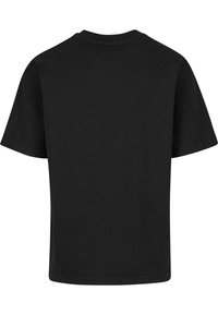 Camiseta de algodón negra con cuello redondo, mangas cortas y corte recto. La tela parece suave, sin patrones ni acentos visibles.
