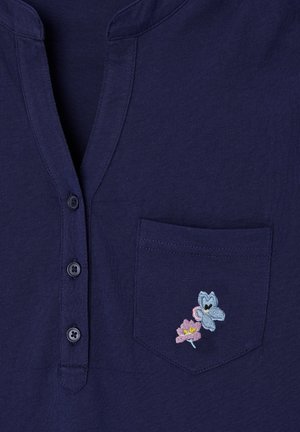 Dunkelblaues Hemd mit drei Knöpfen und einer Brusttasche mit kleinen, bestickten pinken und blauen Blumen.