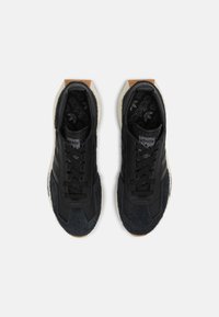 Černé sportovní boty z semiše a textilních materiálů, s texturovanou podrážkou, černými tkaničkami a off-white střední podrážkou.