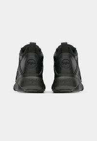 Svart sneaker med ett texturerat läderovre, vadderad krage, dragflik och logodetalj på hälen. Stabil sula med ergonomiska designfunktioner.