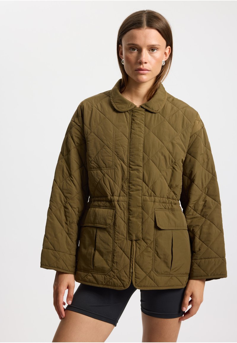 Olivgrüne gesteppte Jacke mit Kragen und tailliertem Schnitt, ausgestattet mit zwei aufgesetzten Fronttaschen. Glatte Textur und leicht.