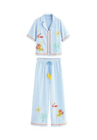 Kék és fehér csíkos pijama szett rövid ujjú pólóval és bő nadrággal. Virág- és trópusi témájú hímzésekkel, sárga bojtokkal. 