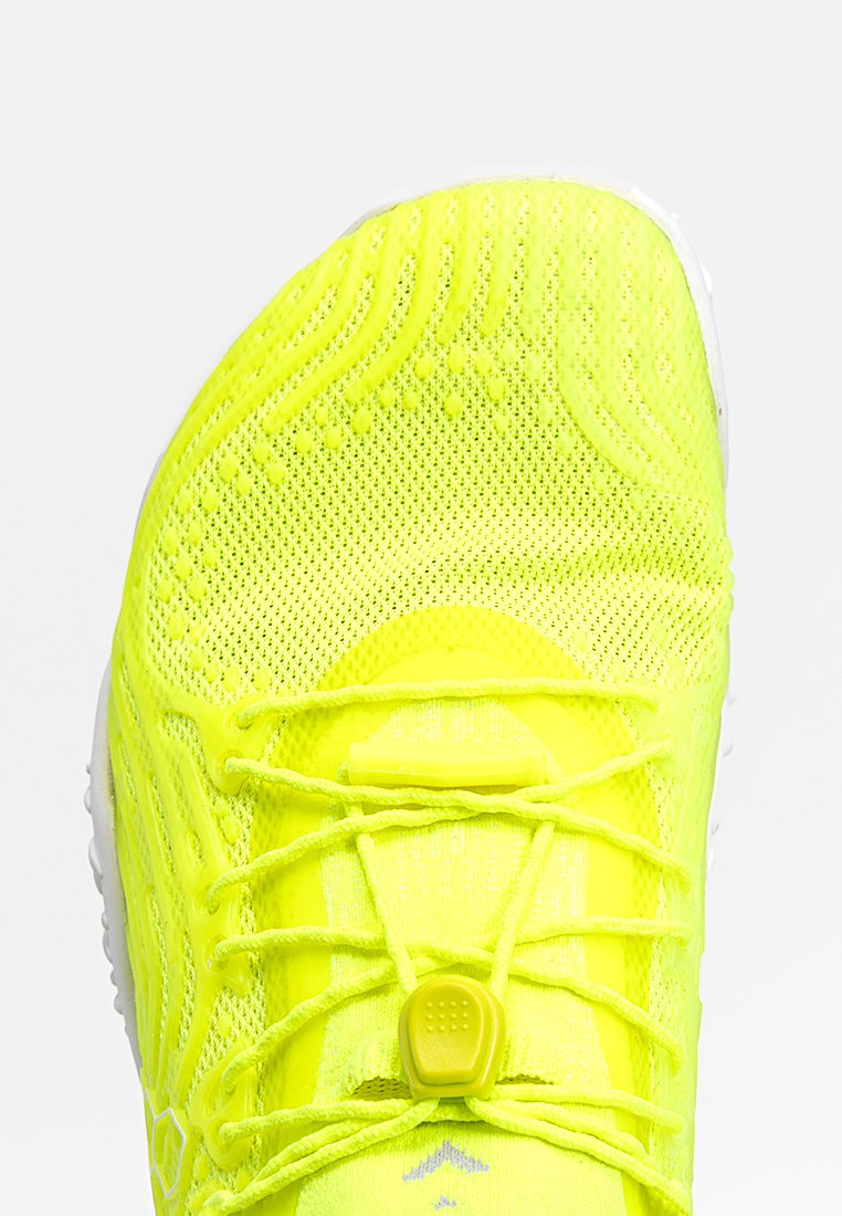 Zapatilla de correr de un brillante color amarillo neón con una parte superior de malla texturizada, sistema de cordones elásticos y un collar acolchado para mayor comodidad.