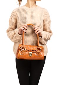 Borsa a mano in pelle marrone con manici arrotondati, dettagli in metallo dorato e chiusura a scatto; presenta dettagli decorativi con anello e pattina.