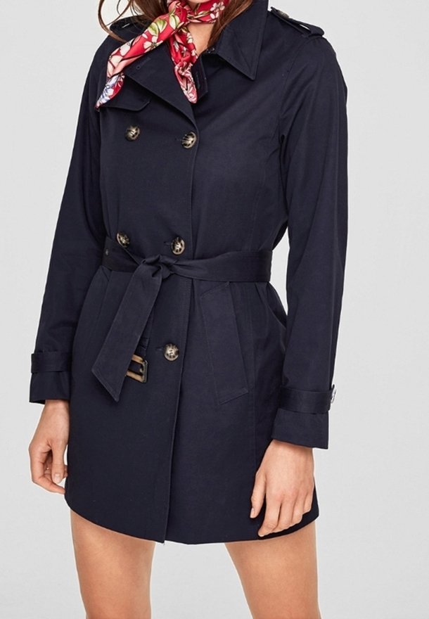 Granatowy płaszcz trenchowy z podwójnym zapięciem, złotymi guzikami, paskiem w talii oraz pagonami na ramionach. Zawiera czerwoną kwiecistą chustę na szyi.