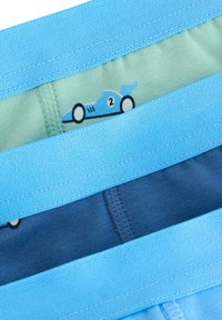 Stak af blå og grønne drengeundertøj med trykte blå racerbiler og kontrastfarvede elastiske linninger.