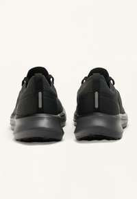 Črni športni čevlji z mrežastim zgornjim delom in gumijastim podplatom. Imajo odsevne poudarke in podložen ovratnik za udobje. Zaobljena oblika.