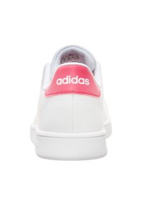 Zapatilla Adidas blanca con parte superior de cuero suave, lengüeta del talón rosa, suela de goma y logotipo en relieve en la parte posterior.