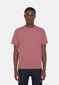 T-shirt rosa a maniche corte in cotone; presenta un collo a giro e un piccolo logo sul lato sinistro del petto. Tessuto morbido, vestibilità casual.