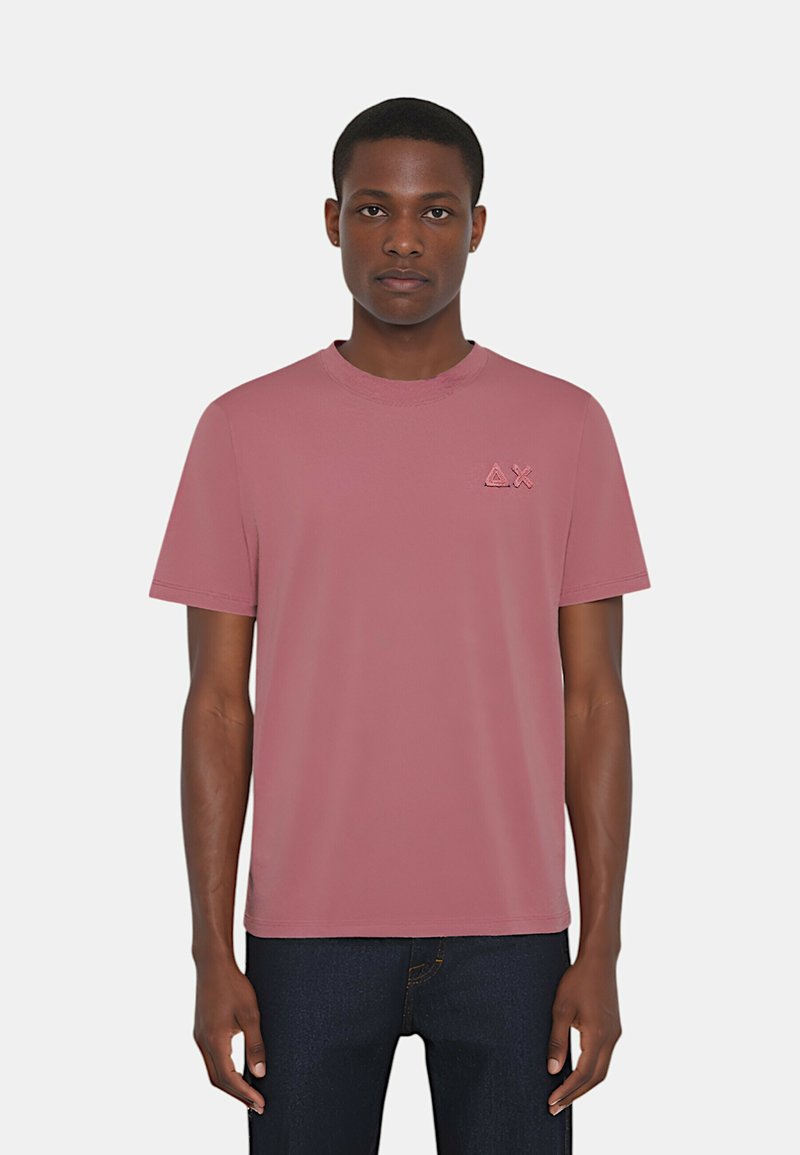 T-shirt rosa a maniche corte in cotone; presenta un collo a giro e un piccolo logo sul lato sinistro del petto. Tessuto morbido, vestibilità casual.