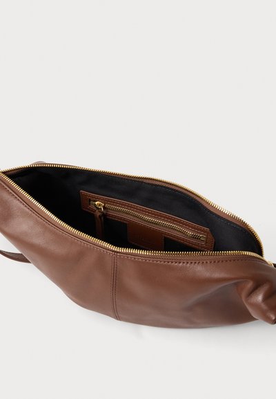 Pochette en cuir marron avec fermeture éclair dorée, partiellement ouverte pour révéler l'intérieur en tissu noir et une petite poche zippée à l'intérieur.