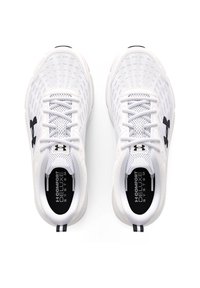 Zapatillas deportivas blancas con parte superior de malla, puntera redonda, cordones planos y logo negro. Presenta una plantilla negra con el texto "SISTEMA COMFORT DELUXE".
