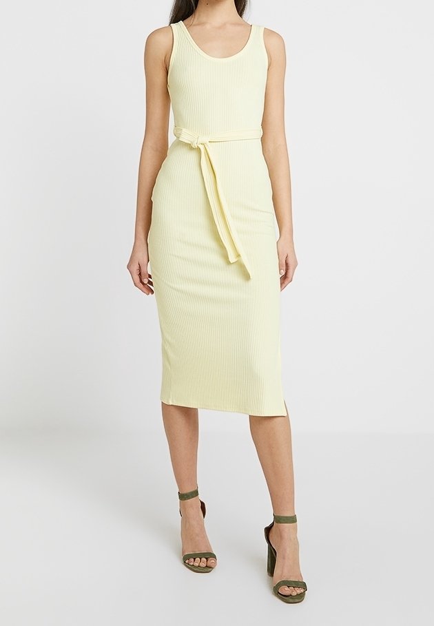 Gul ribbad midiklänning med rundad halsringning, midja med bälte och rak silhuett. Matchad med gröna klacksandaler.