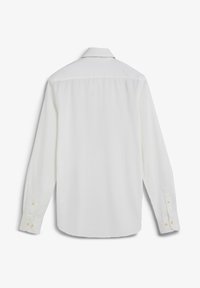 Camisa blanca de manga larga con cuello clásico, puños con botones y una textura lisa. Vista trasera muestra canesú en los hombros y sin estampados.