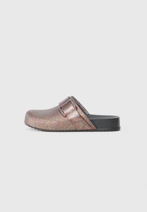 Glittery clogs with a rounded toe, a metallic buckle accent, and a sturdy black sole. The upper features a multicolored shimmering texture.