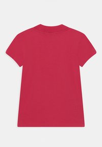 Krótki rękaw koszulka T-shirt z jasnoróżowego materiału bawełnianego. Klasyczny okrągły dekolt, luźny krój, bezszwowe ramiona i gładka tekstura.