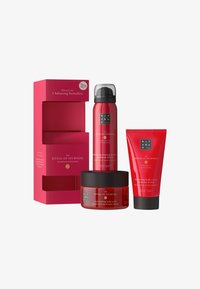Set regalo rosso contenente tre prodotti: gel doccia schiumoso, esfoliante corpo ringiovanente e crema corpo equilibrante, tutti in packaging elegante.