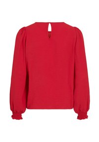 Blusa roja de manga larga con escote en forma de lágrima en la parte trasera, puños fruncidos y tejido texturizado con un corte relajado. Sin patrones visibles ni herrajes.