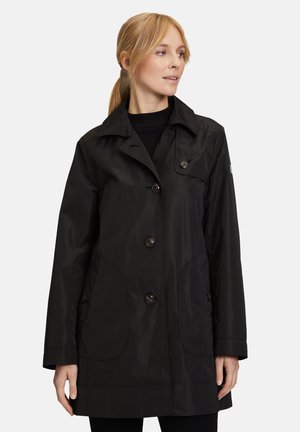 Black waterproof jacket featuring a button-up front, two side pockets, and a collar. Smooth texture with a relaxed fit and classic design.