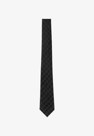 Nœud papillon noir avec un motif texturé de formes ovales interconnectées, fabriqué à partir d'un tissu lisse. Extrémités effilées et largeur uniforme sur toute la longueur.