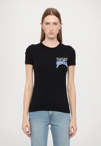T-shirt nera aderente in cotone, con maniche corte e un logo grafico blu e bianco sul lato sinistro del petto.