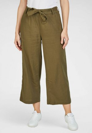 Pantalons à larges jambes de couleur vert olive, fabriqués en tissu léger avec une taille ceinturée et une texture douce ; associés à des baskets blanches.