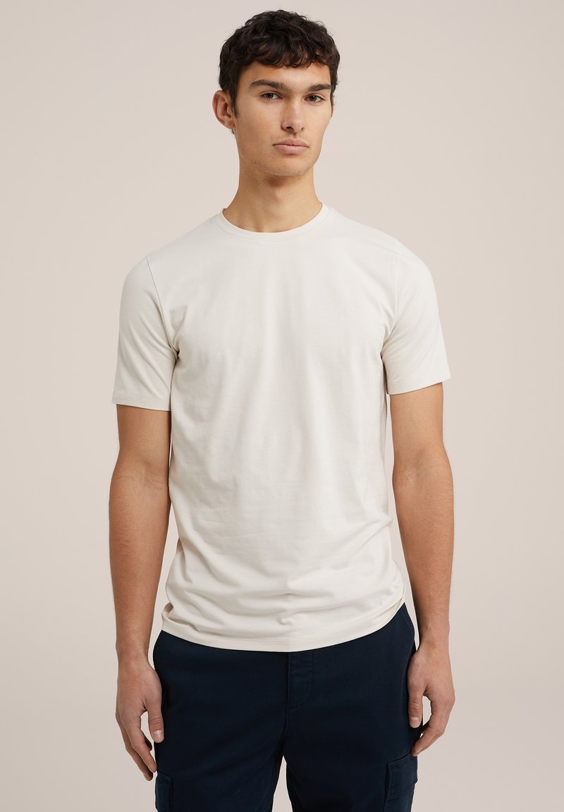 Tricou scurt de culoare bej deschis, confecționat din bumbac moale, cu guler rotund și un design ajustat. Purtați-l cu pantaloni de culoare bleumarin închis.