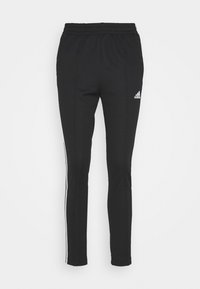 Svarta träningsbyxor med elastisk midja, slim fit, sidofickor och vita vertikala ränder. Har en Adidas-logotyp på vänster ben.