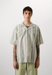 Chemise à manches courtes avec des rayures verticales en vert, gris et blanc, dotée d'une fermeture à boutons et de deux poches avant. En matière mélangée coton.