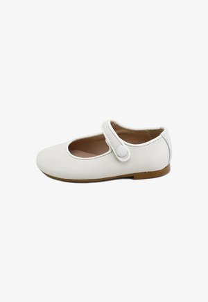 Zapato plano Mary Jane blanco con puntera redondeada, correa ajustable con detalle de botón y suela marrón claro.