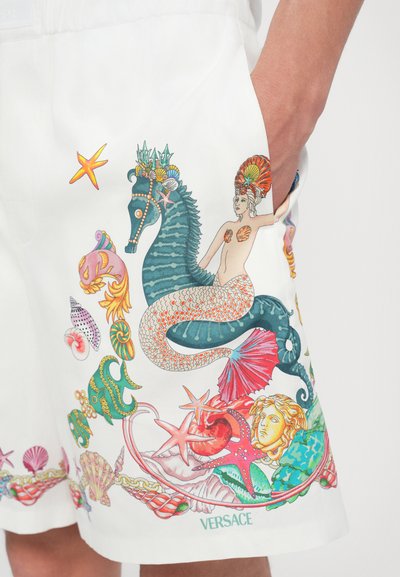 White shorts featuring colorful ocean-themed prints, including a seahorse, mermaid, shells, and sea creatures, with intricate details and textures.