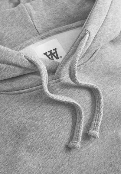 Gray hoodie with a textured fabric, featuring a drawstring and a logo tag inside. The design includes a front pocket area and a double-lined hood.