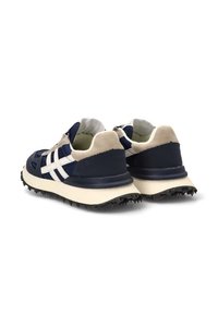 Zapatillas deportivas en color marino y crema con suela texturizada, rayas blancas y cuello acolchado. Presentan un upper duradero y acentos contrastantes.