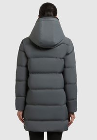 Manteau en duvet gris avec capuche, texture matelassée et design mi-long. Le tissu semble lisse avec une finition mate.