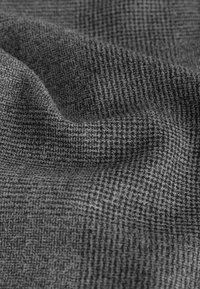 Gråt tekstureret stof med et lille ternmønster, der har et blødt, glat udseende og en let glans, egnet til forskellige tekstilanvendelser.