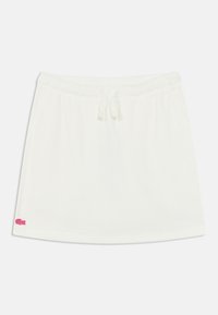 Άσπρη βαμβακερή φούστα με ελαστική μέση και κορδόνι, με μικρό ροζ λογότυπο στο κάτω αριστερό μέρος. Λείο ύφασμα, casual σχέδιο.