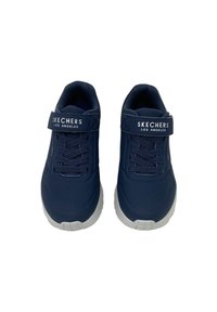 Sneakers Skechers blu navy con una parte superiore in materiale sintetico liscio, lacci elastici e una fascia con chiusura a strappo. Suola in gomma bianca con superficie antiscivolo.