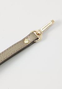 Grå läderrem med en strukturert yta, som har en klips i guldton och varumärkesdetalj, säkrad med en dekorativ metallsnäpp.