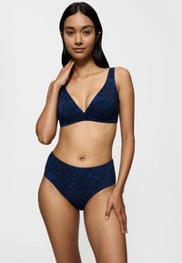 Navy-blaue Bikini-Kombination bestehend aus einem V-Ausschnitt-Bralette mit breiten Trägern und einem hochgeschnittenen Unterteil, beide mit einem abstrakten Linienmuster verziert.