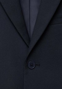 Blazer blu navy con tessuto strutturato, chiusura con un bottone e rever a punta. Presenta un bottone abbinate e dettagli di cucitura pulita.