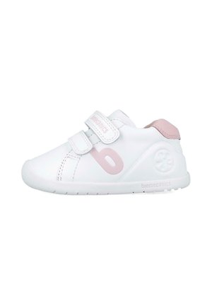 Zapatilla blanca con acentos en rosa, que cuenta con dos correas de Velcro, una puntera redondeada y un logo en el lateral. Fabricada con material sintético suave.