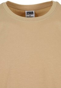 Beige t-shirt met ronde hals van katoen, met een gladde textuur en een label met de tekst "URBAN CLASSICS, Made in Bangladesh."