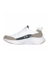 Zapatilla deportiva blanca con acentos grises y marinos, tejido texturizado y suela gruesa blanca. Presenta cordones tradicionales y una tira de agarre.