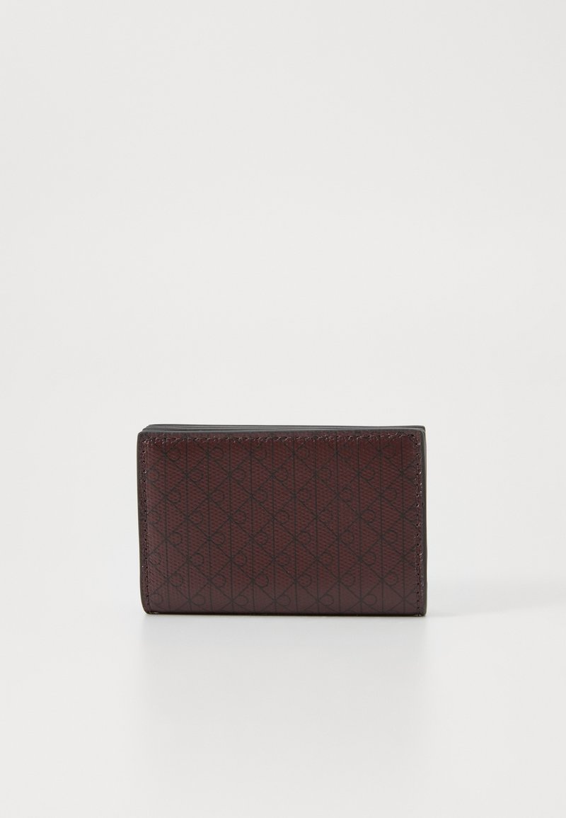 Maroon leather wallet featuring a geometric embossed pattern, rectangular shape, and sleek edges, suitable for cards and cash.