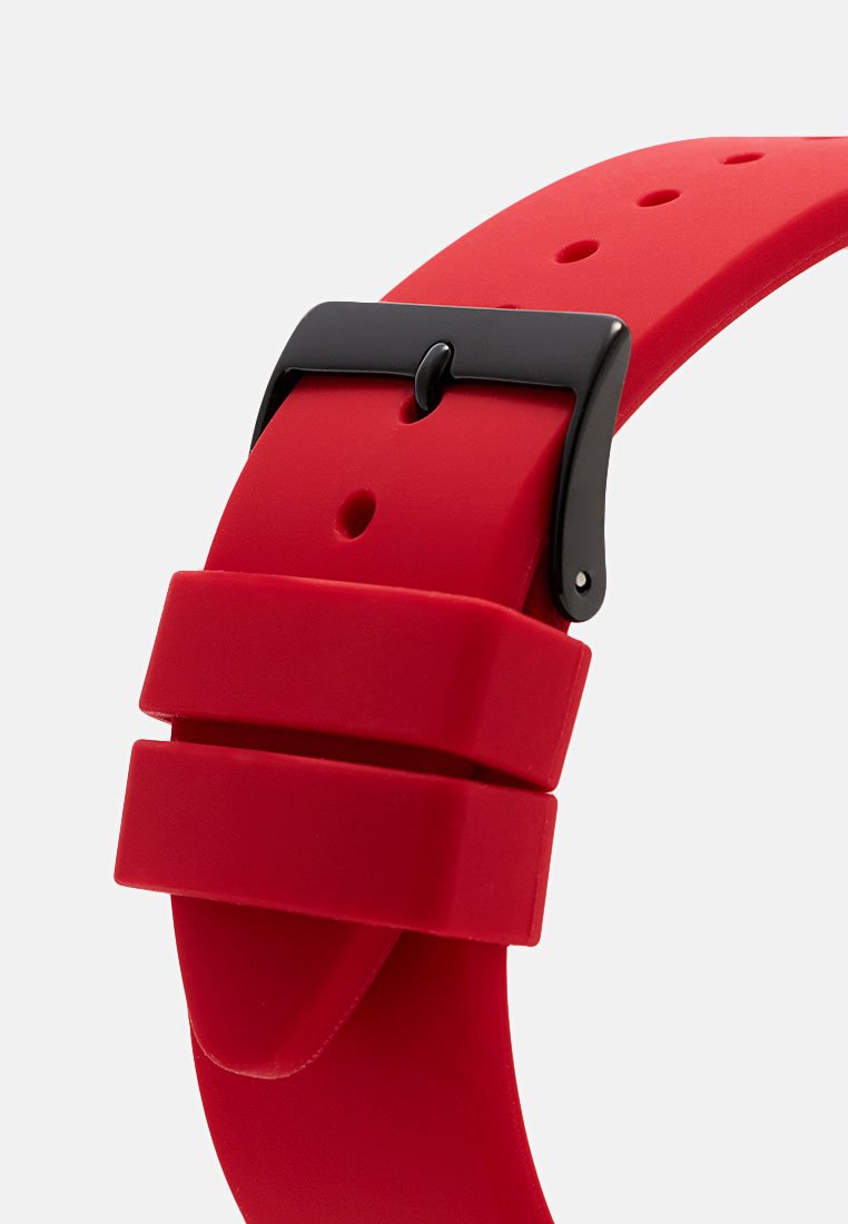 Correa de reloj de silicona roja con textura suave, que cuenta con una hebilla de metal negra y dos pasadores ajustables para asegurar la correa.