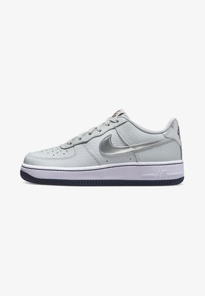 Zapatilla Nike Air Force 1 baja gris con logo plateado metálico y media suela blanca sobre fondo blanco.
