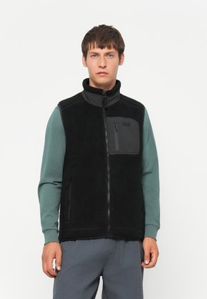 Black fleece vest with zippered front, stand-up collar, and a chest pocket. Features textured material, and is worn over a teal long-sleeve shirt.